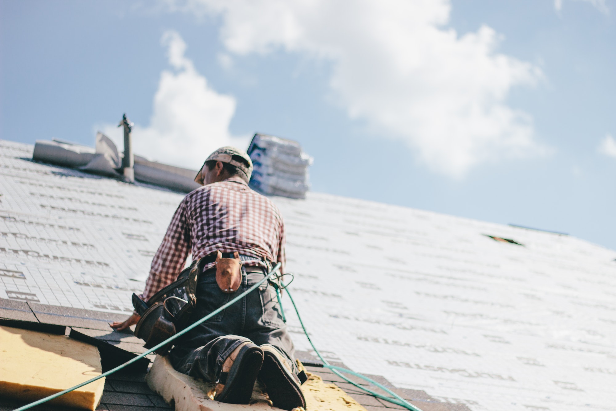 roof repairs roofing insurance claims new roof Roofer adding shingles to the roof of a house orlando